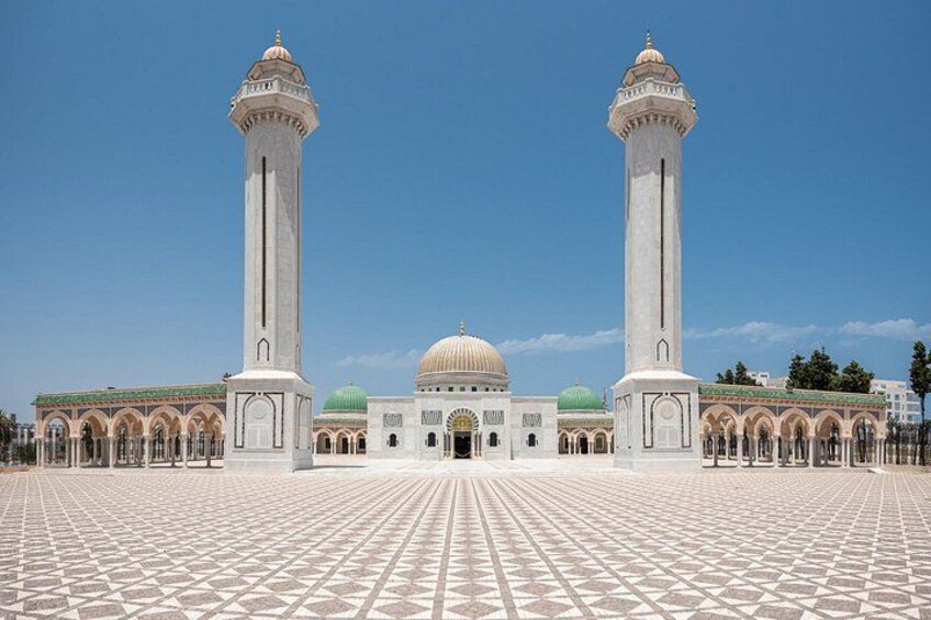 Une mosquée dotée de deux minarets imposants, d’un grand dôme central et d’une cour ornée de carreaux décoratifs. 2