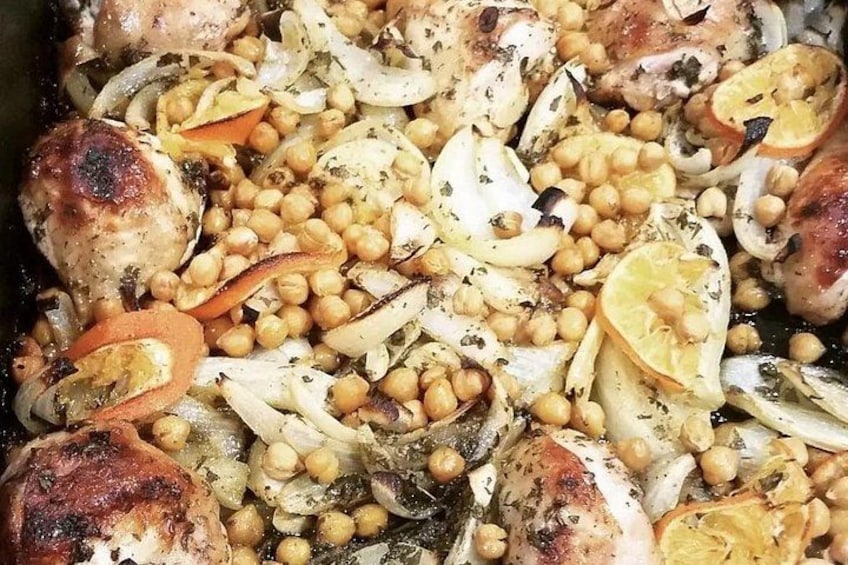 Roasted chicken, chickpeas, onions, and lemon slices in a dish. 3