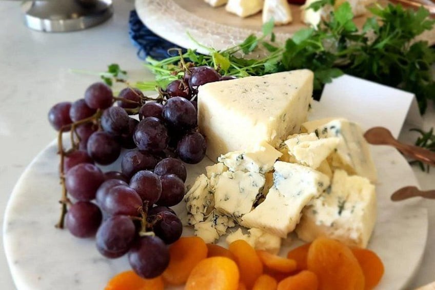 A plate with cheese, grapes, and carrots. 4