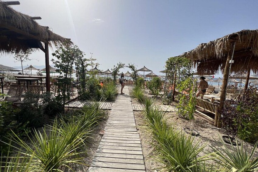 Un sendero de madera que conduce a sombrillas de playa y a la zona de la playa. 2