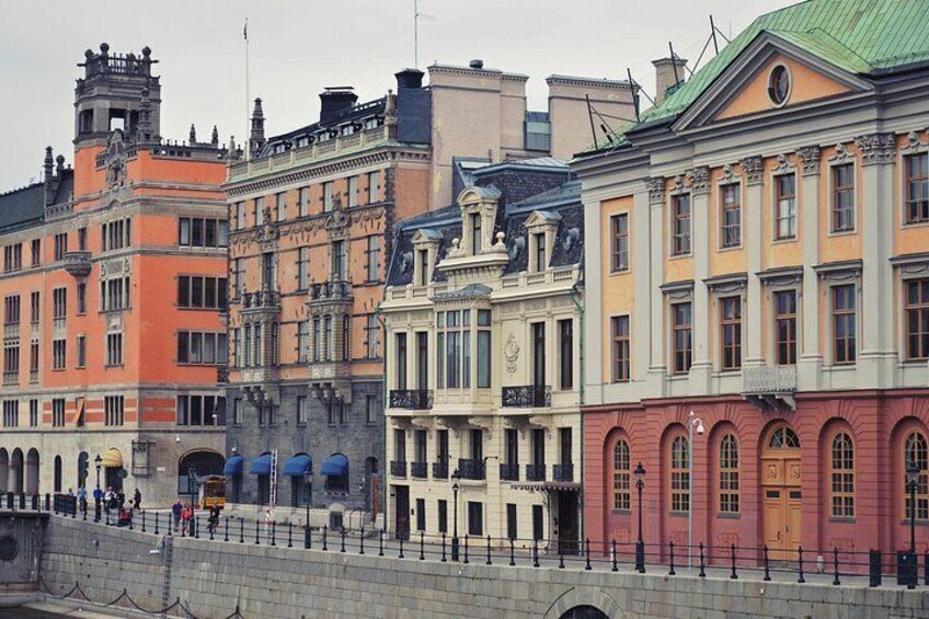 A row of colorful historic buildings along a waterfront promenade. 4
