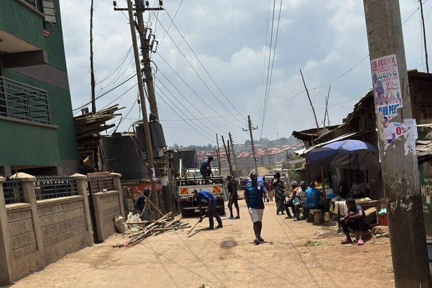 A busy street with people walking, a parked truck, and makeshift stalls. 5