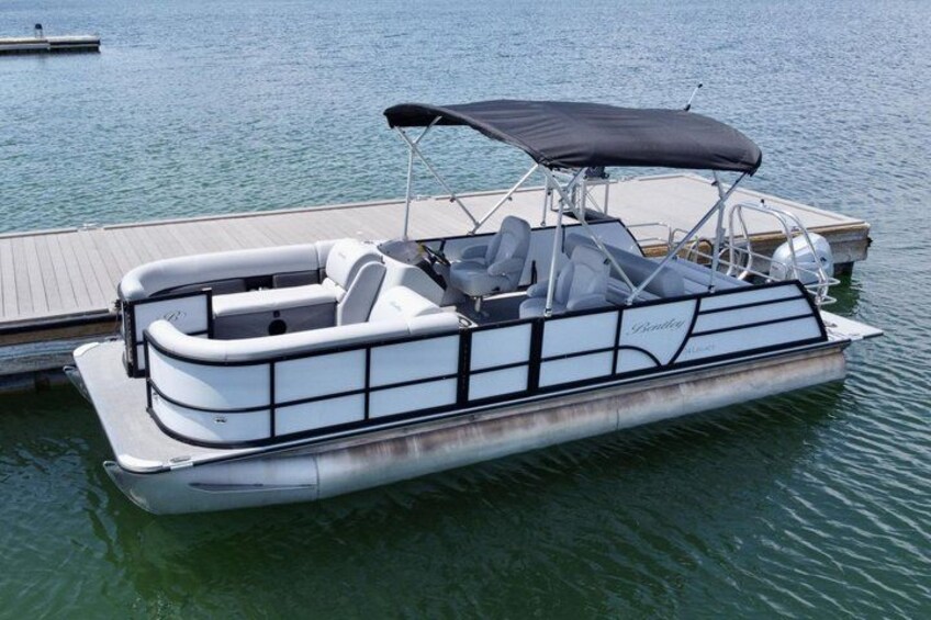 A pontoon boat docked at a wooden pier. 3