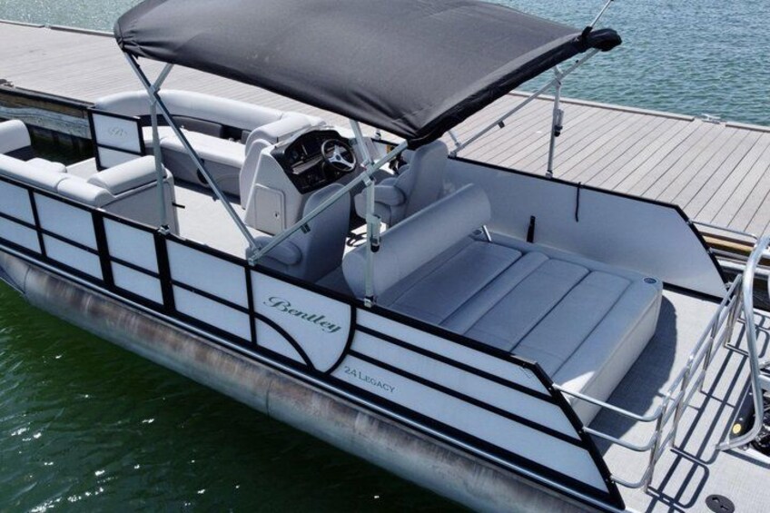 A stationary boat with a covered seating area and a brand name 'Bentley' on the side. 2