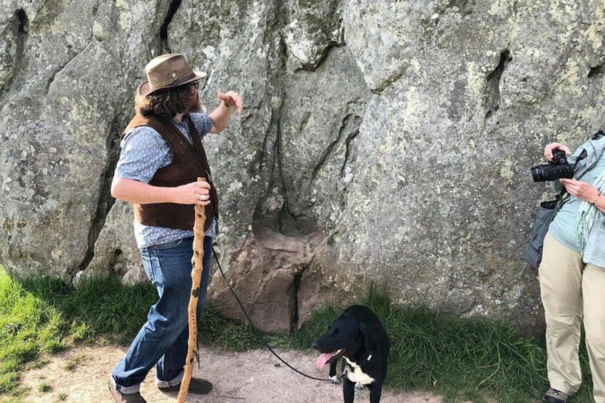 A person with a camera and a dog in a rocky outdoor setting. 2