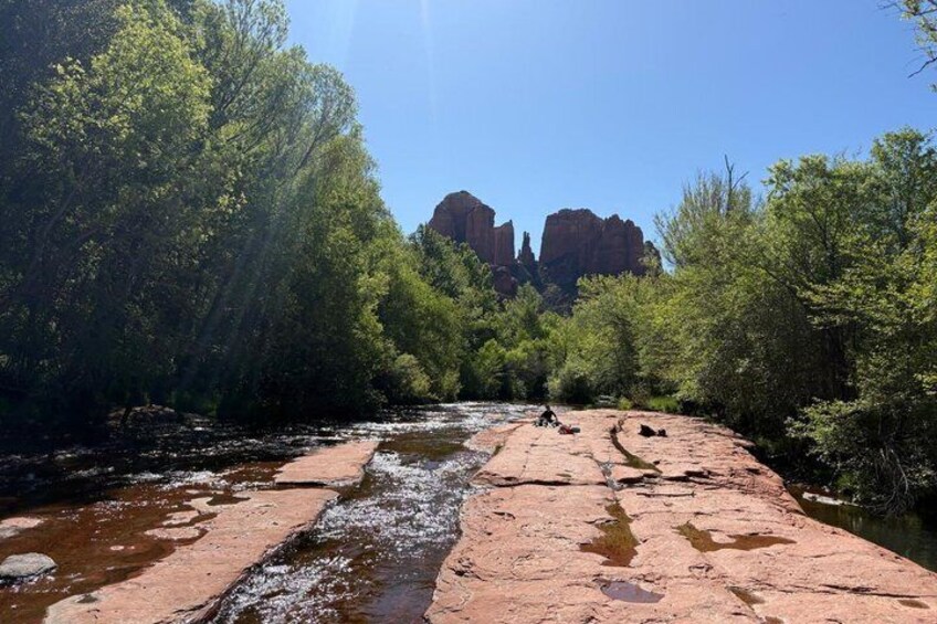 A river flowing through a canyon with red rock formations and green trees. 2