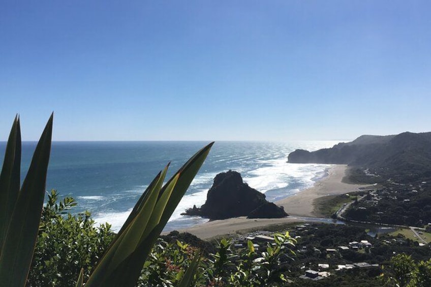 A coastal landscape with a beach, ocean, and rocky cliffs. 1