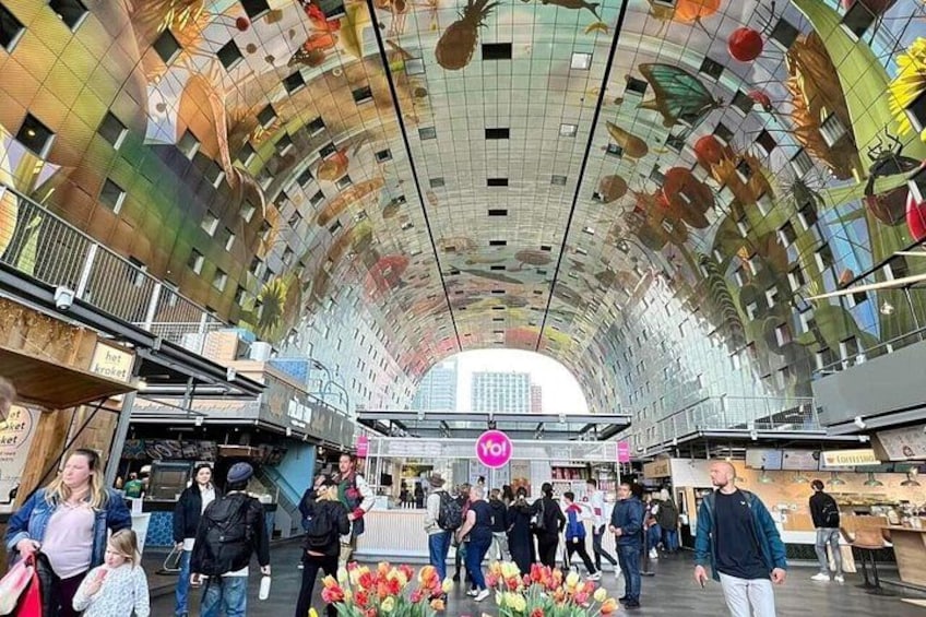 A modern indoor market with a curved ceiling and various stalls. 4