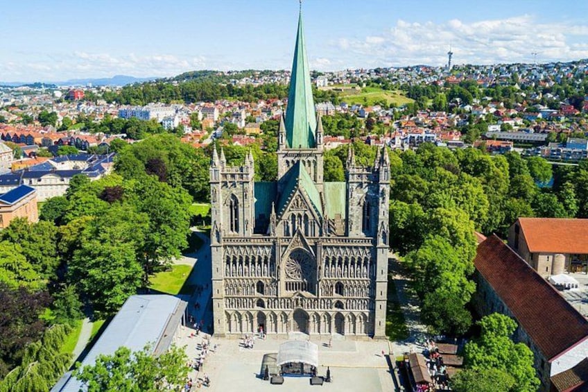 A cathedral with a tall spire, surrounded by trees and buildings. 2