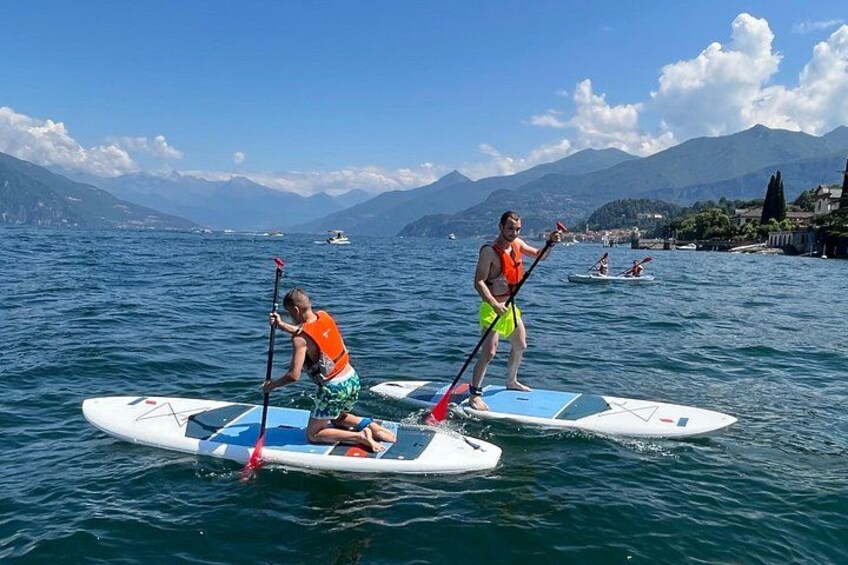 Two people paddleboarding on a lake with mountains in the background. 4