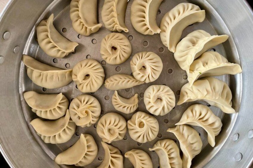 A steamer tray with various dumplings. 5