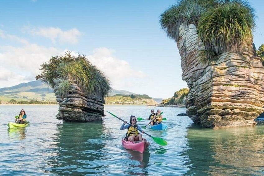 People kayaking on a calm lake with unique rock formations. 4