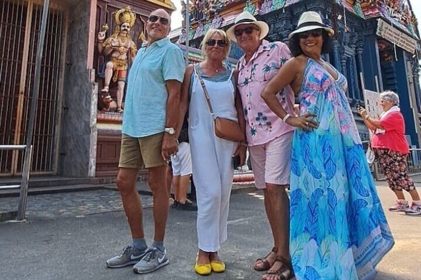 Un grupo de personas de pie frente a un templo con una estatua. 1