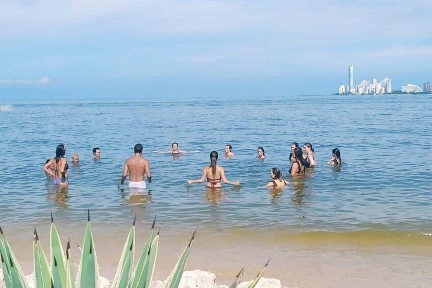 Mensen zwemmen in het water, met een stadsachtergrond op de achtergrond. 3