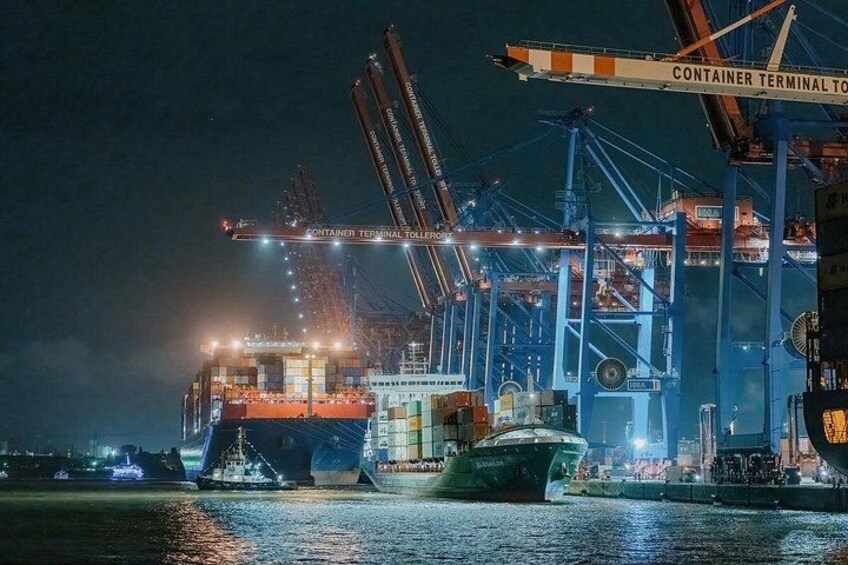 A container terminal at night with cranes and ships. 5