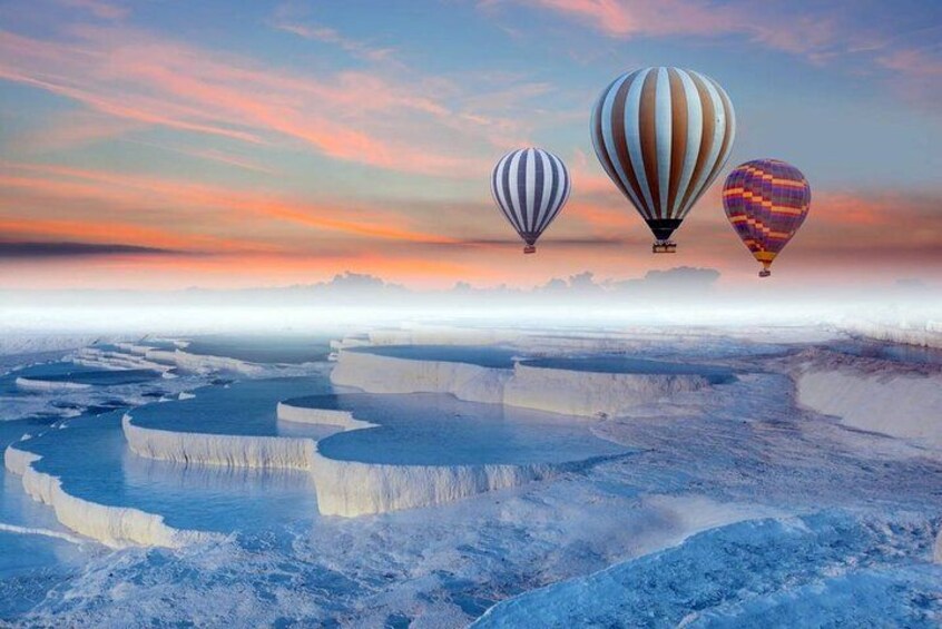 A landscape with terraced formations and three hot air balloons in the sky. 2