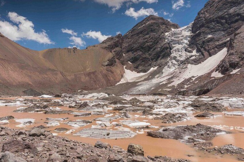 A mountainous landscape with snow patches, rocky terrain, and a clear sky. 2