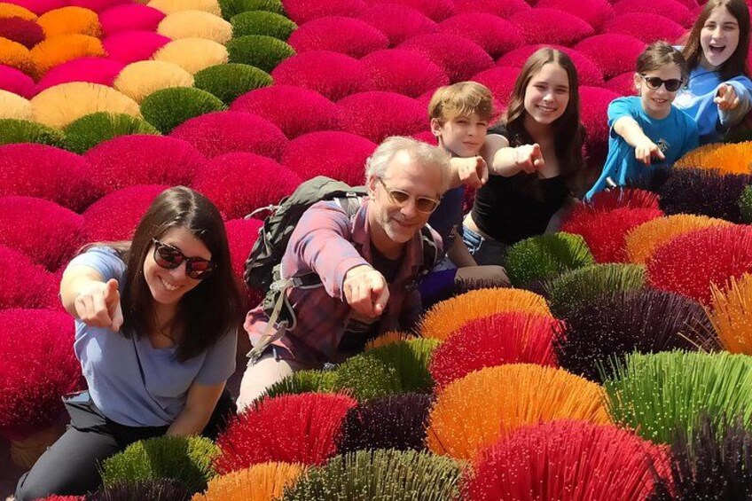 A group of people surrounded by colorful spherical plants. 2