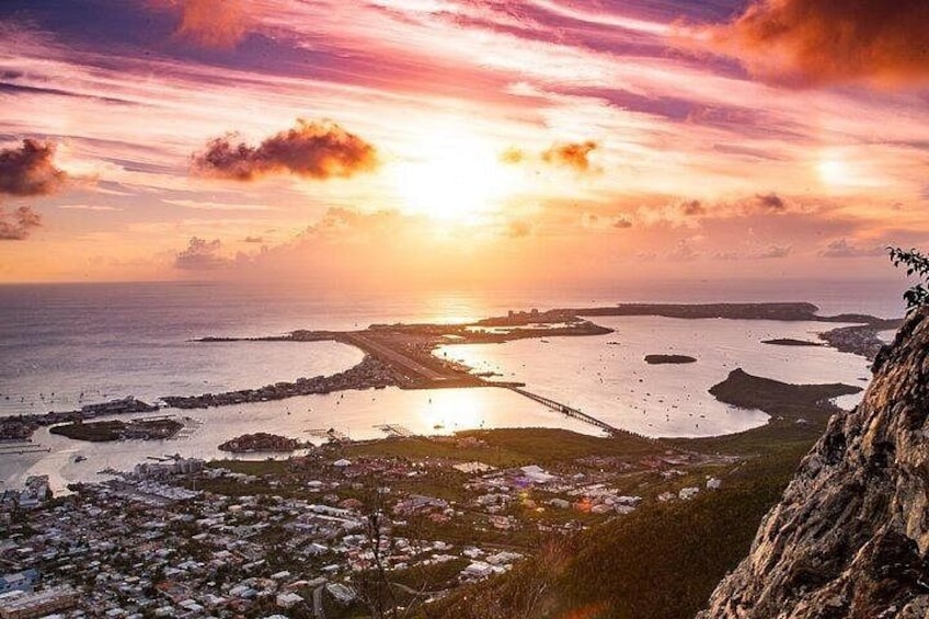 A coastal sunset with a bridge, water bodies, and a rocky cliff. 3