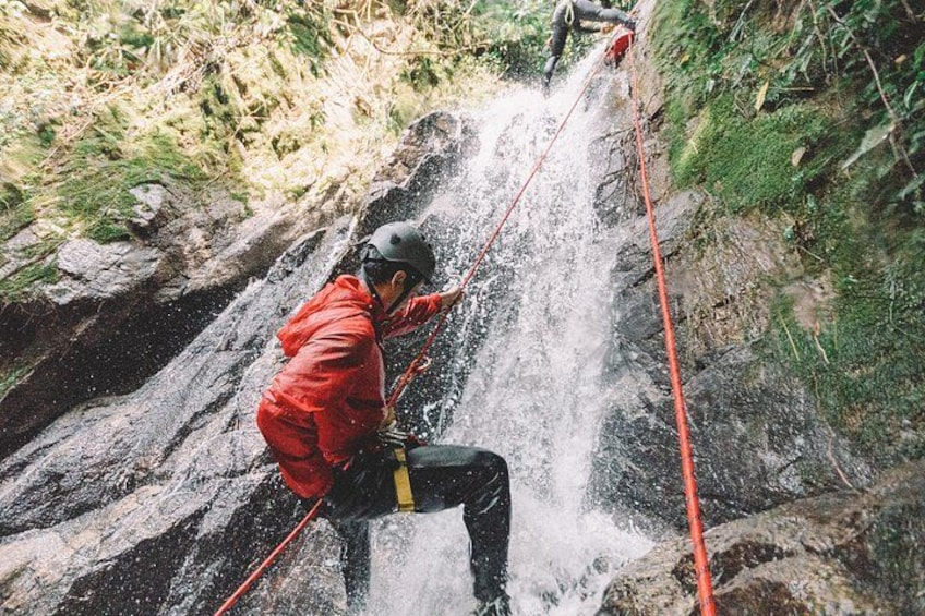 A person rappelling down a waterfall. 1