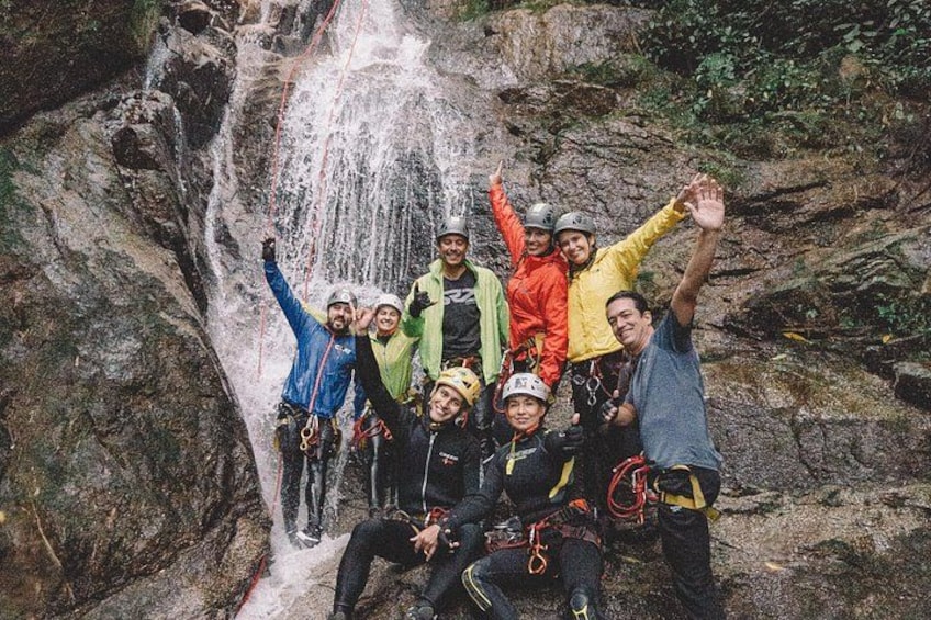 A group of people rappelling down a waterfall. 2