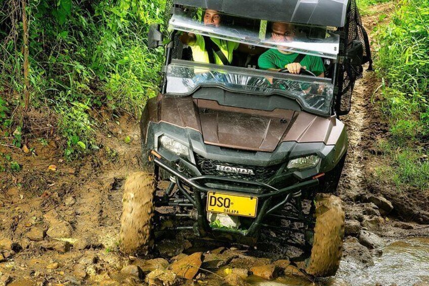 Un véhicule se déplaçant sur un terrain boueux, avec un ruisseau à proximité. 3