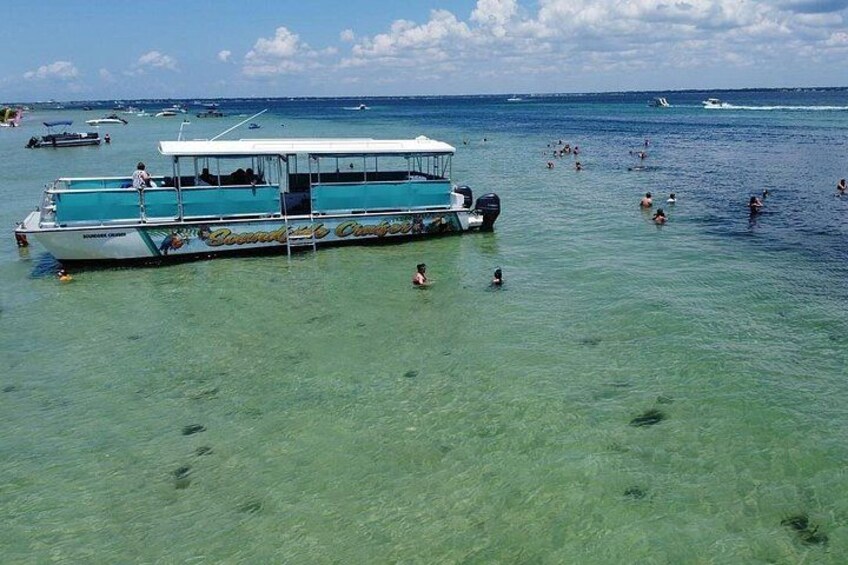 A boat with people swimming in the water. 2