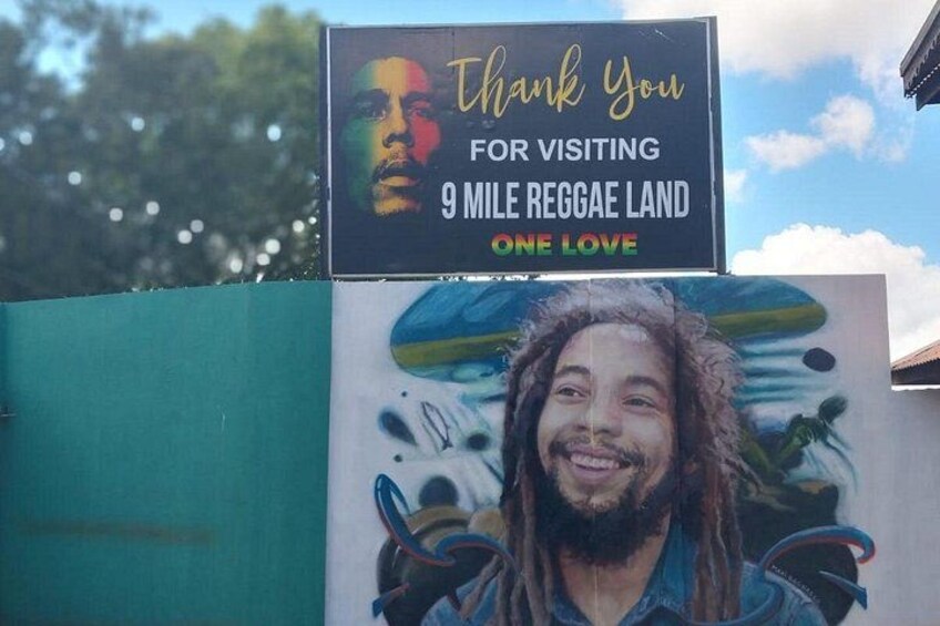 A thank you sign for visiting 9 Mile Reggae Land with a mural of a person with dreadlocks. 2