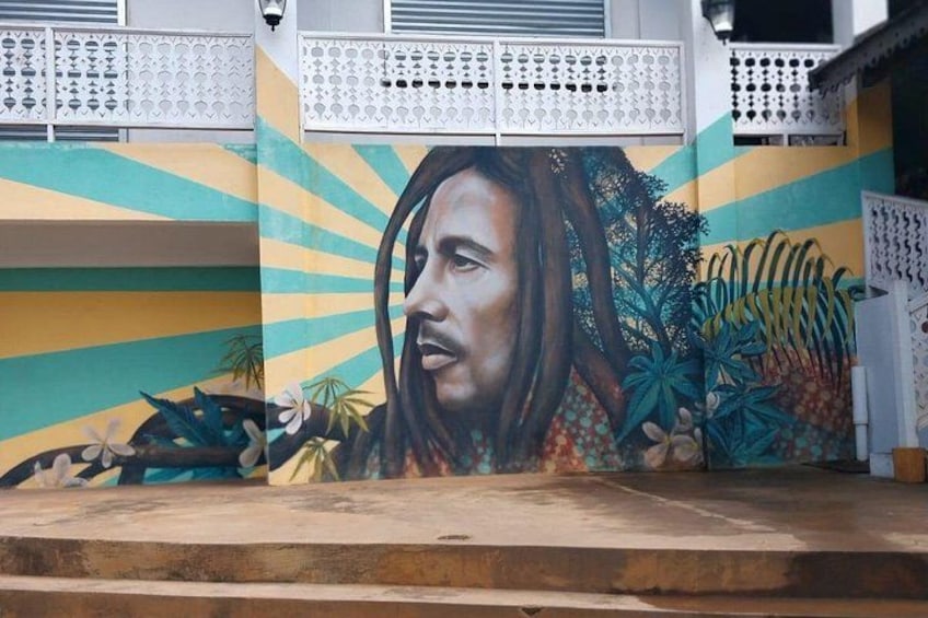 A mural with tropical foliage and a figure. 3
