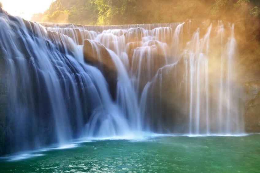 A waterfall cascading over a rocky cliff into a pool of water. 1