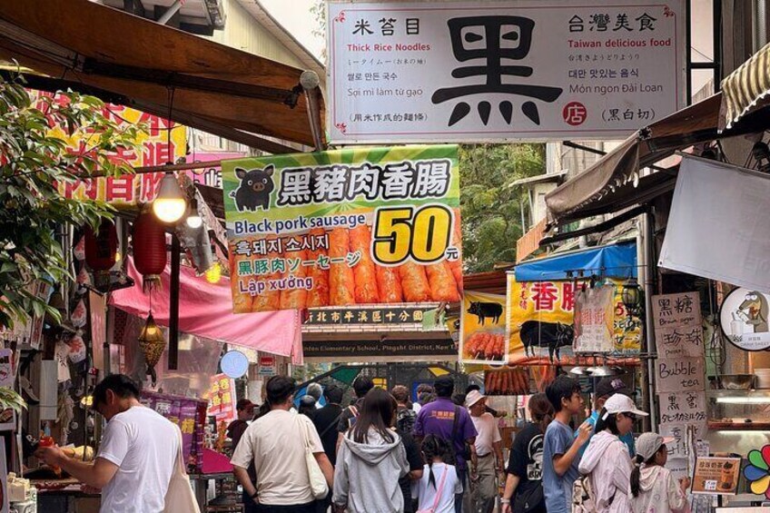 A busy street market with various food stalls and signs in a foreign language. 5