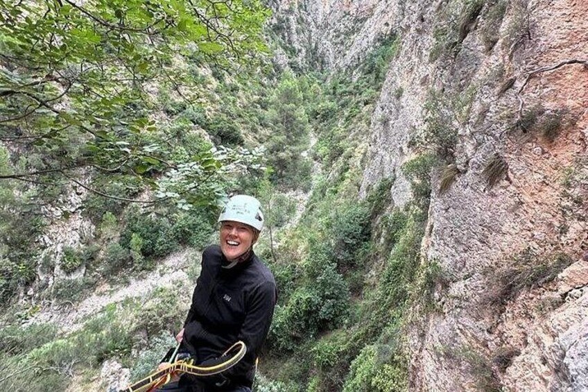Eine Person besteigt einen steilen, felsigen Berg mit Vegetation. 2