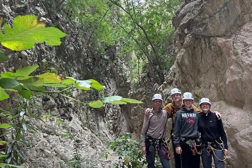 Eine Gruppe von Menschen mit Helmen und Kletterausrüstung in einer felsigen Outdoor-Umgebung. 3