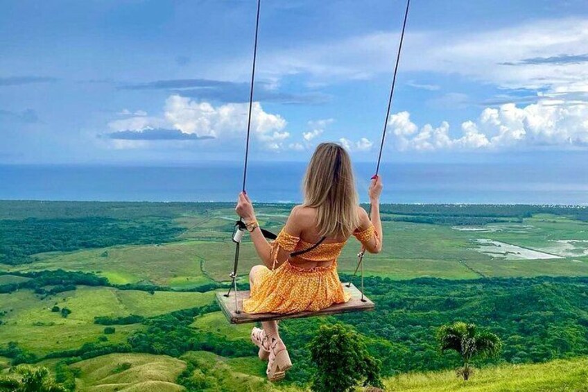A person on a swing overlooking a landscape. 4