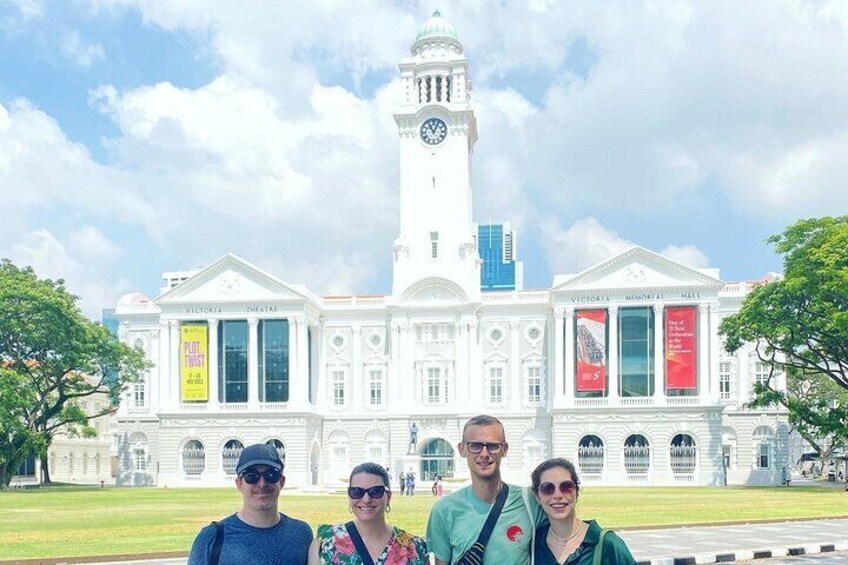 A large white building with a clock tower, banners, and columns. 4