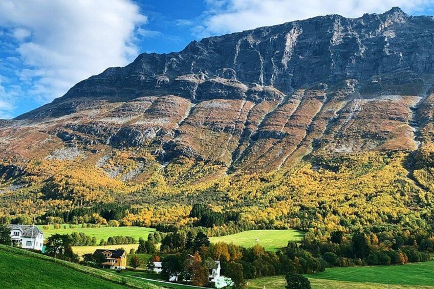A mountainous landscape with autumn foliage, a house, and a clear sky. 2