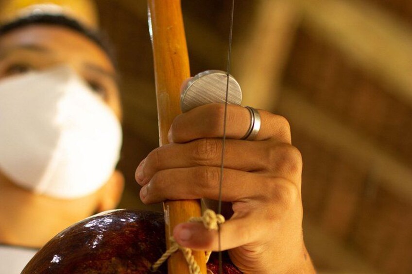 A person holding a wooden stick with a rope. 2