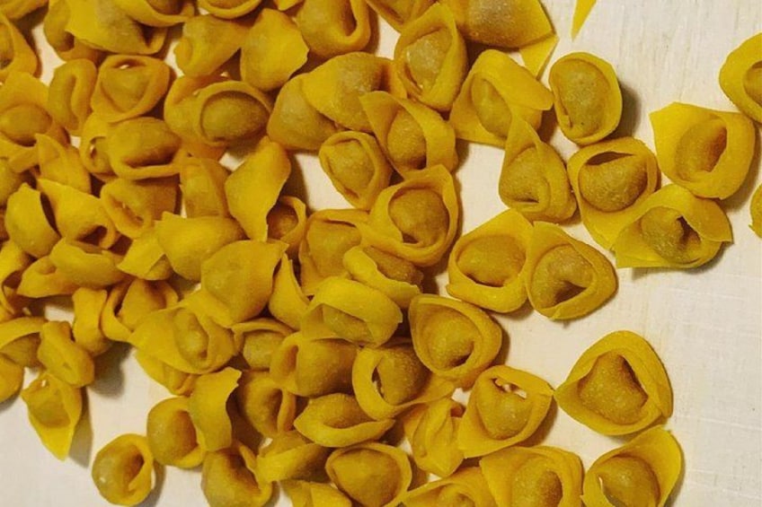 Een hoop gele pasta op een witte ondergrond. 2