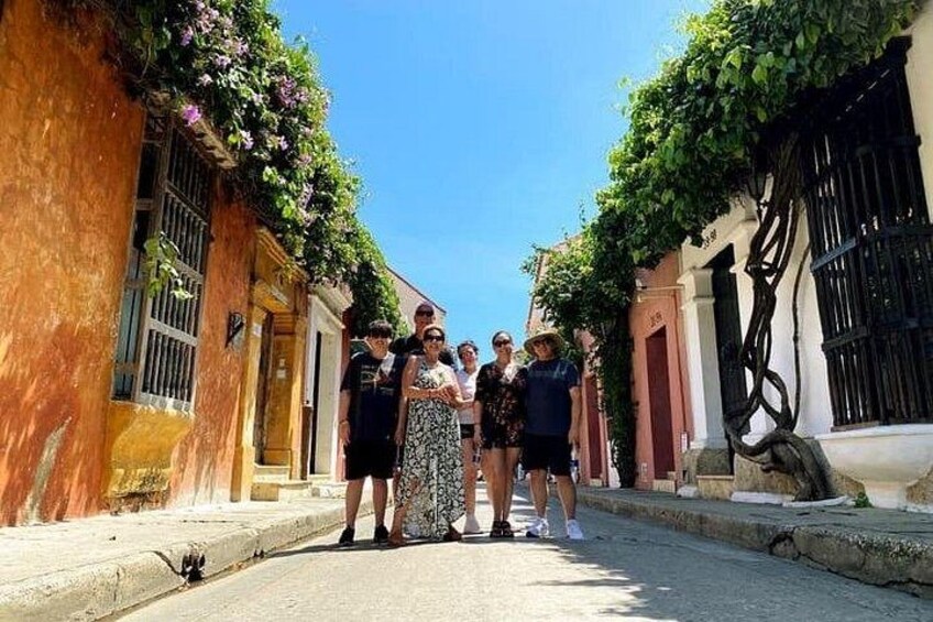 A group of people walking down a narrow street with buildings on either side. 2