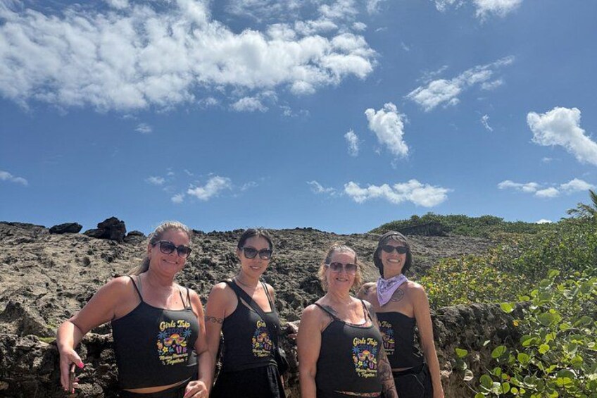 Four people standing on a rocky terrain with a clear sky. 5