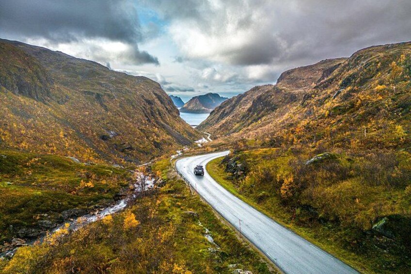 A winding road through a mountainous landscape with autumn foliage. 2