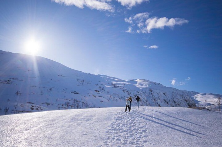 Paisaje montañoso nevado con cielo despejado y el sol brillando. 5