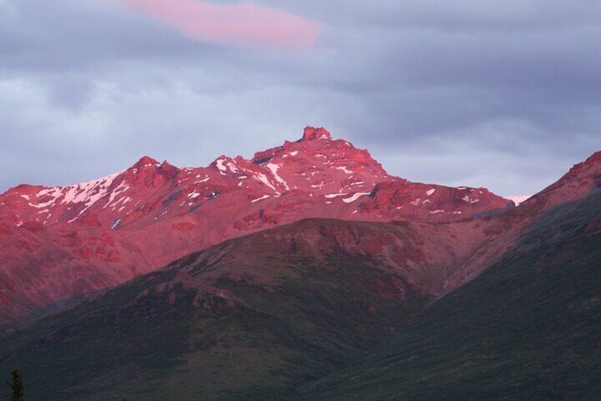 A mountain range with snow-capped peaks and a cloudy sky. 5