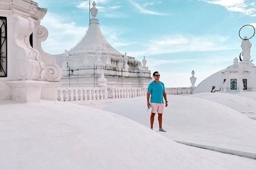 A person standing in a snowy landscape with white buildings and domed structures. 2