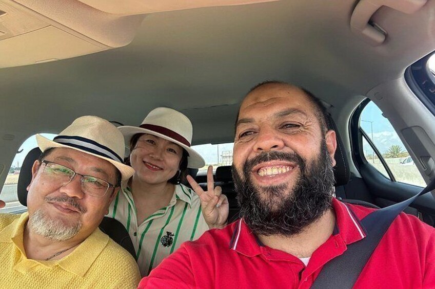 Three people in a car, one wearing a red shirt and another in a yellow shirt. 5