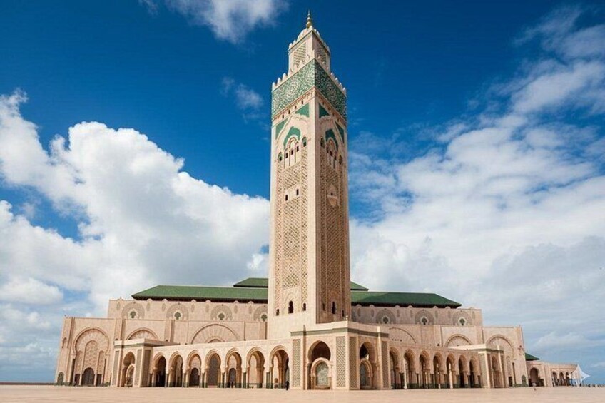 A large mosque with a tall minaret and multiple arches. 5