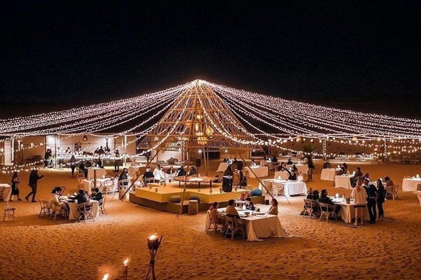 An outdoor dining area with tables and chairs, string lights, and a central structure. 4