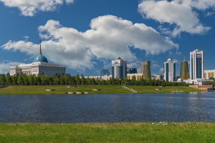 A cityscape with a prominent blue-domed building, a body of water, and a clear sky. 2