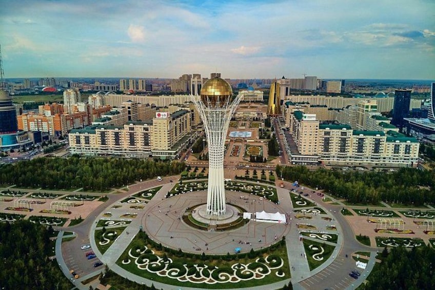 A cityscape with a prominent tower, a circular plaza, and surrounding buildings. 5