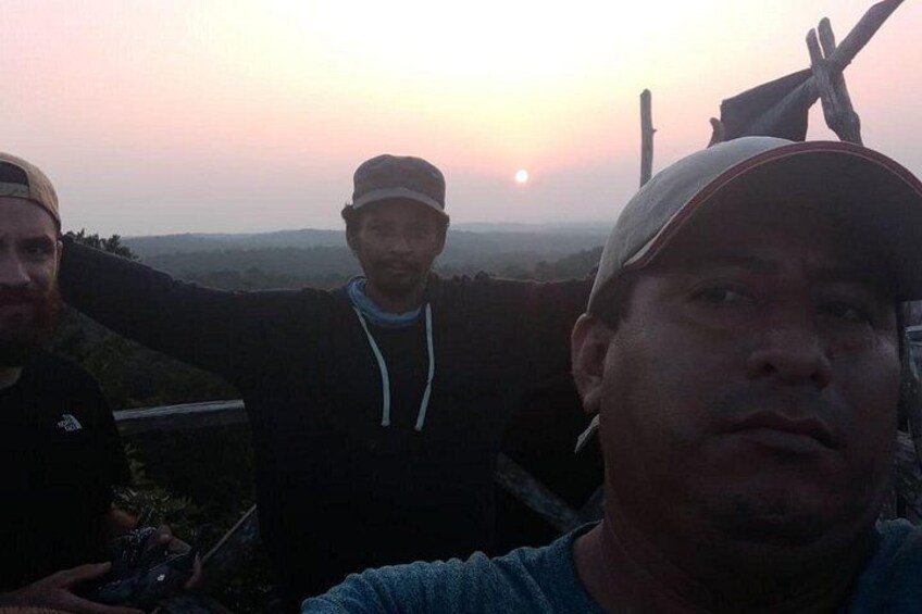 Three people standing outdoors during sunset. 5